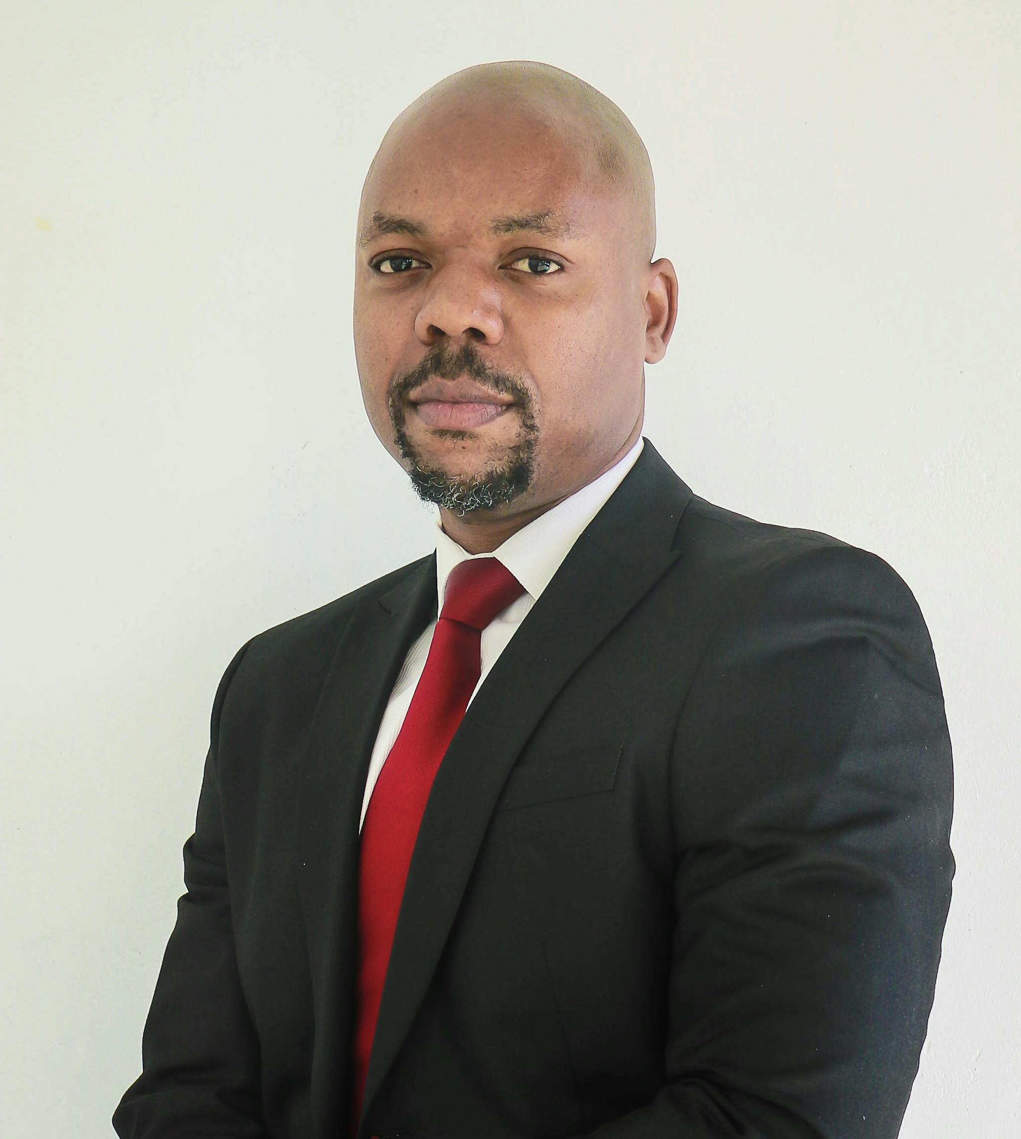 B Mathebula in his work outfit (A black suit, with a white shirt and red tie)